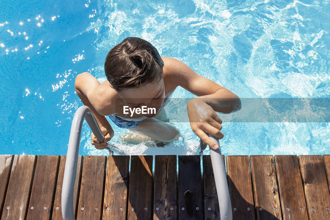 High angle view of shirtless boy in swimming pool