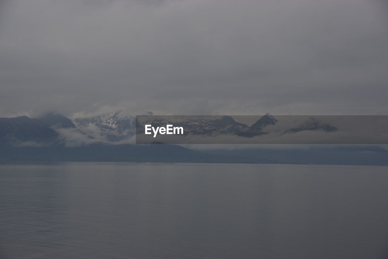 SCENIC VIEW OF SEA AGAINST MOUNTAIN RANGE