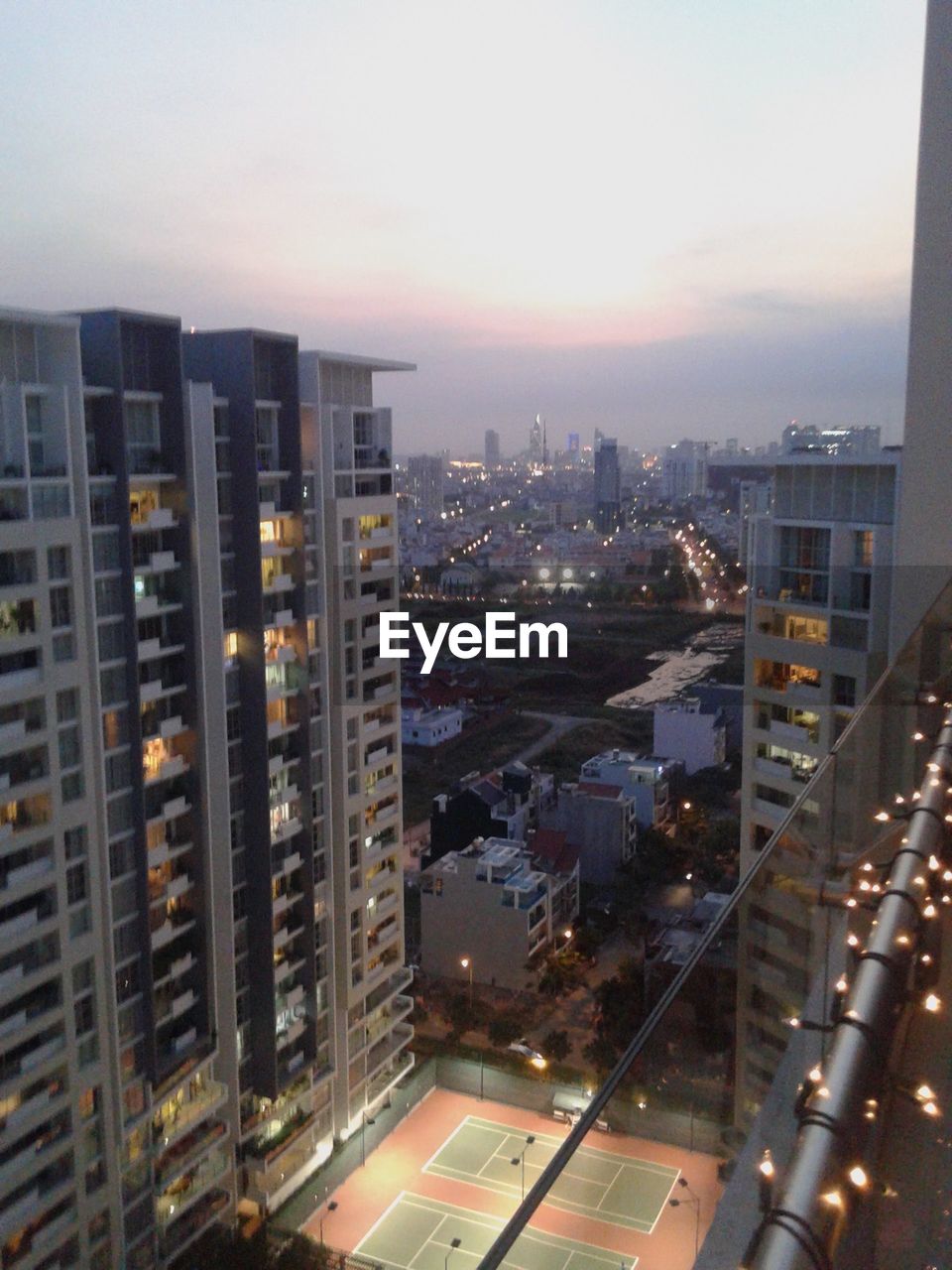 HIGH ANGLE VIEW OF ILLUMINATED CITYSCAPE AT DUSK