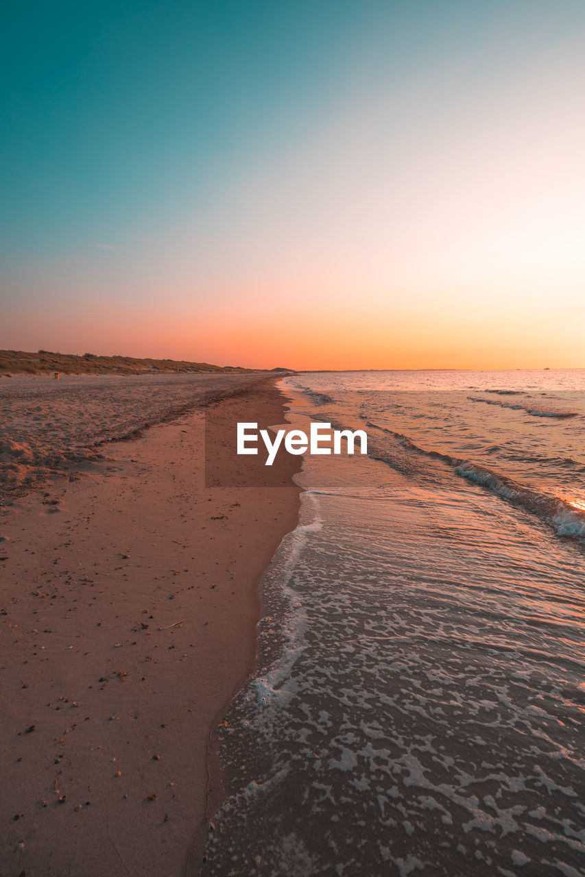 SCENIC VIEW OF SEA AGAINST CLEAR SKY DURING SUNSET