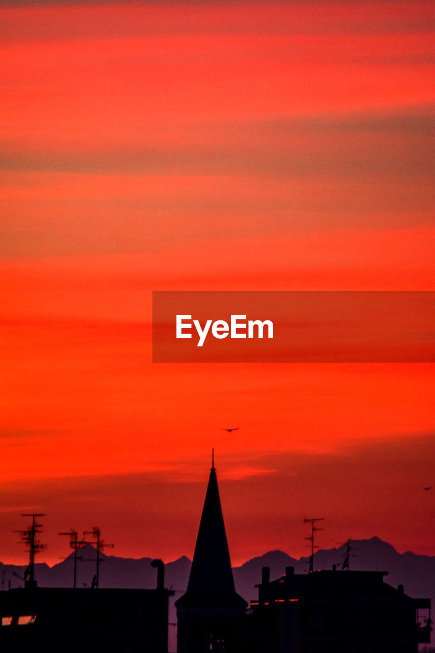 SILHOUETTE BUILDINGS AGAINST ORANGE SKY