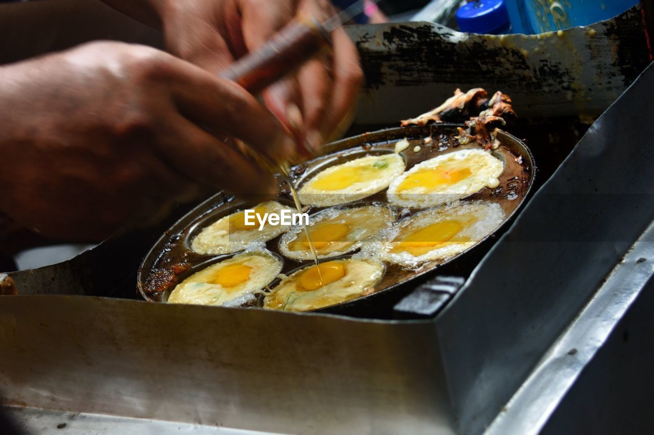 Cropped image of man boiling eggs on stove