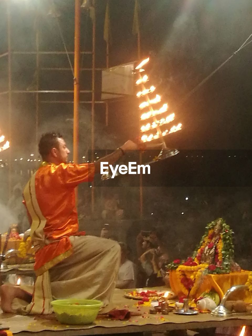 SIDE VIEW OF PEOPLE AT ILLUMINATED TEMPLE