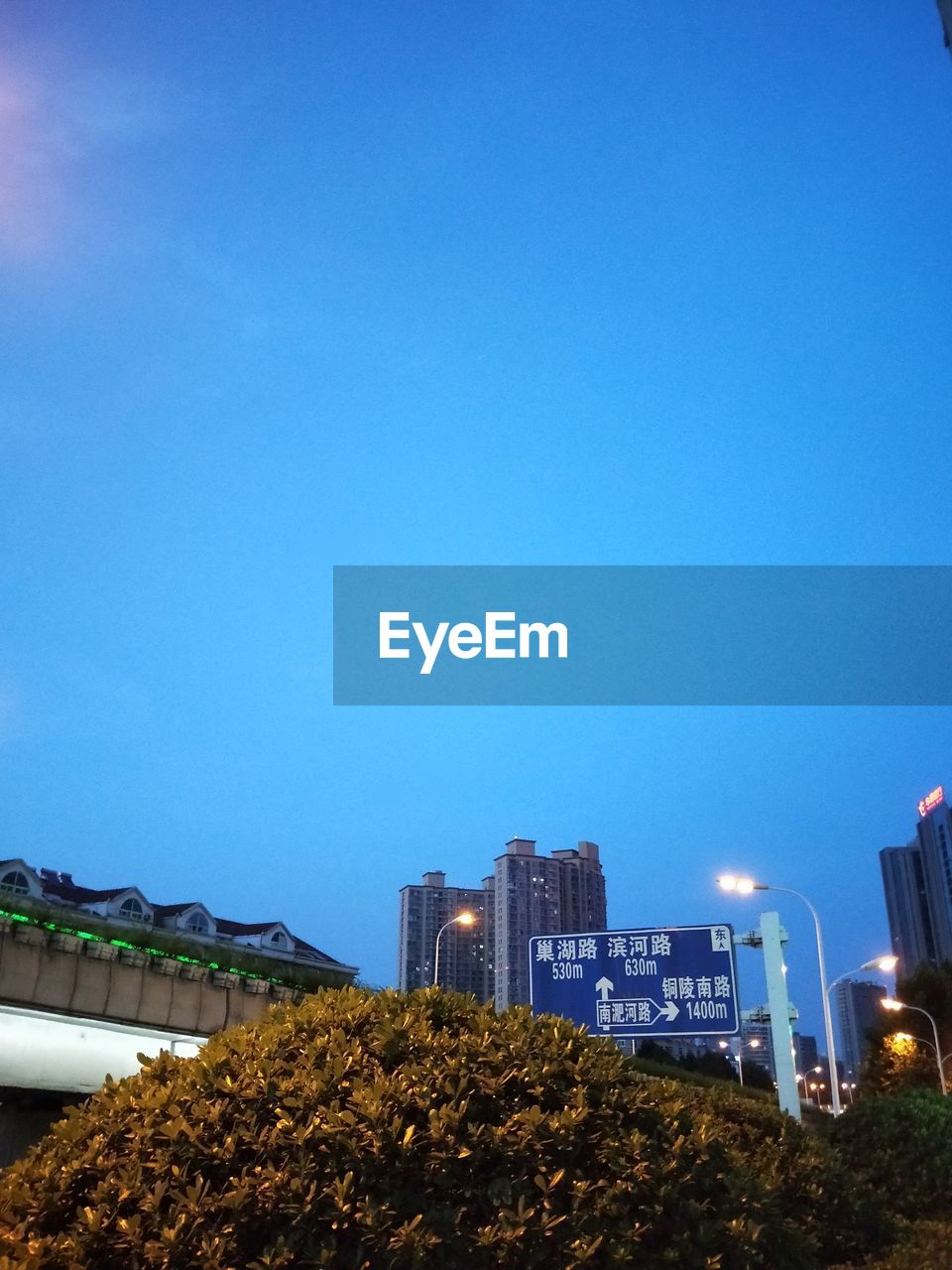 LOW ANGLE VIEW OF ILLUMINATED BUILDINGS AGAINST CLEAR SKY