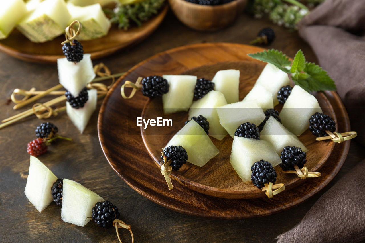 Festive snack of fruit and berry canapes. halloween party food. canapes with melon and blackberries