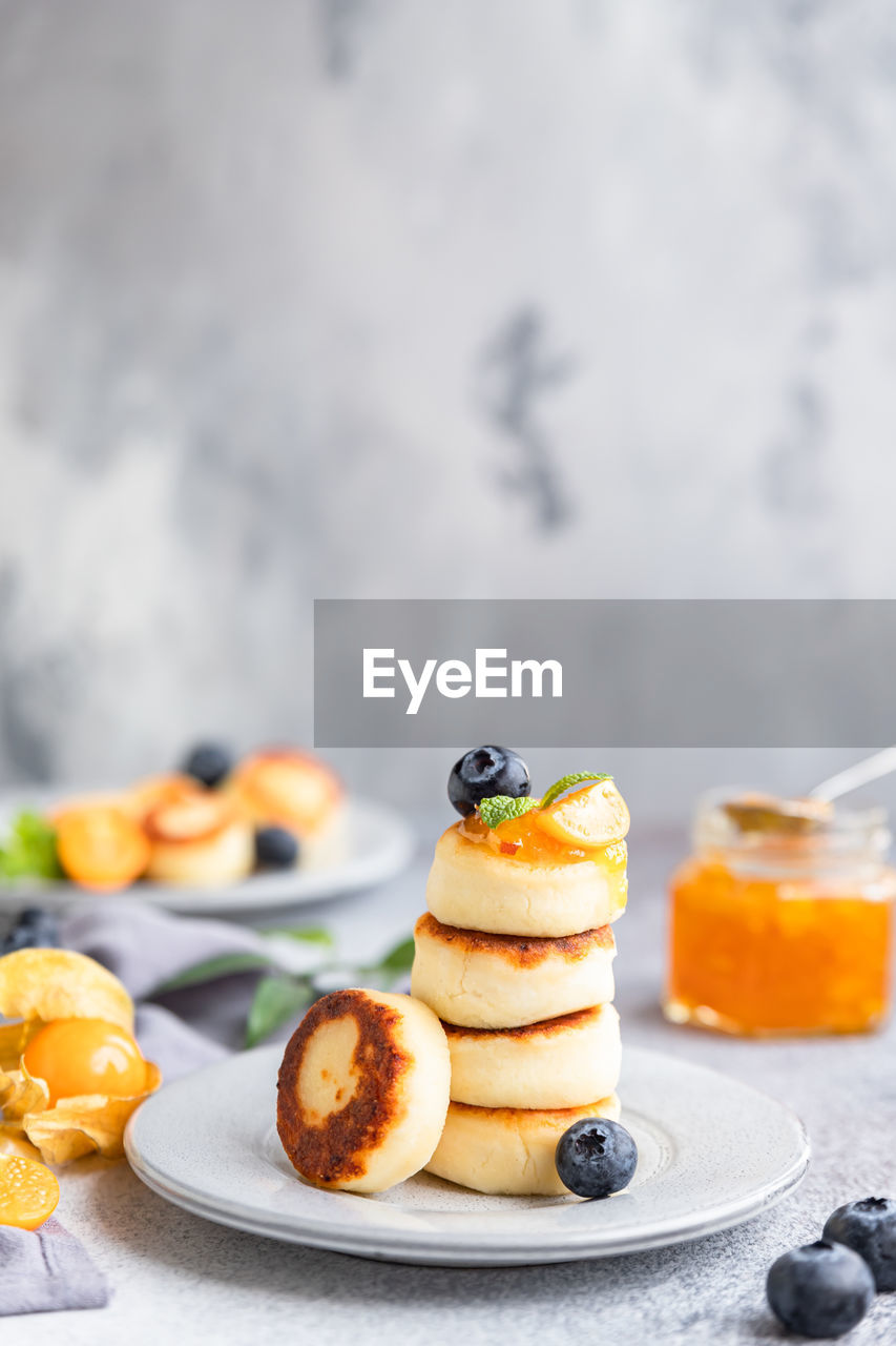 Cottage cheese pancakes, sweet curd fritters with blueberry and physalis