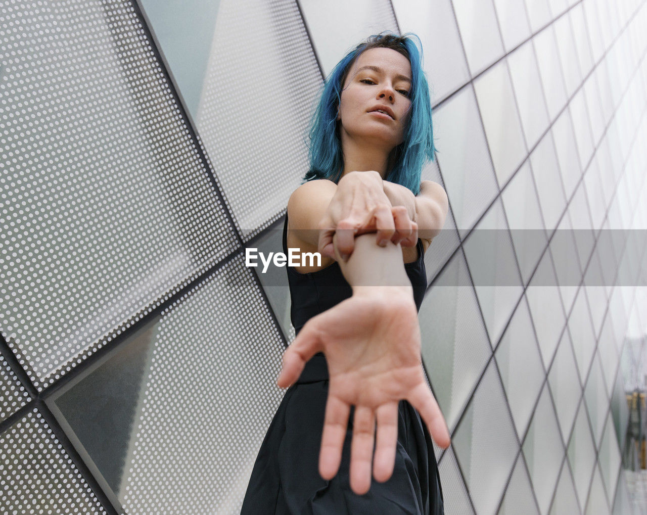 Young woman scratching on hand in front of modern building