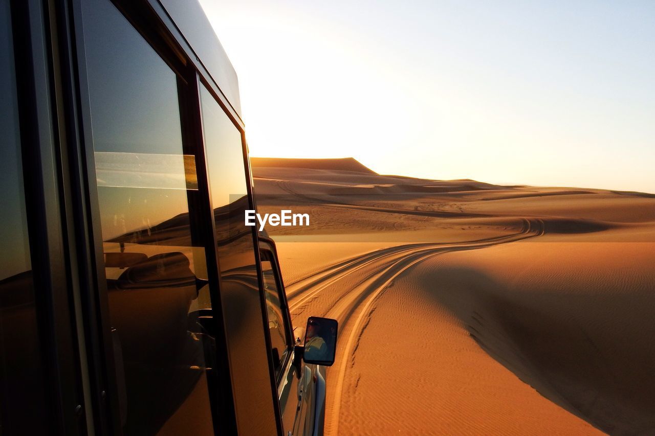 Off-road vehicle on sand dunes of namib desert against sky