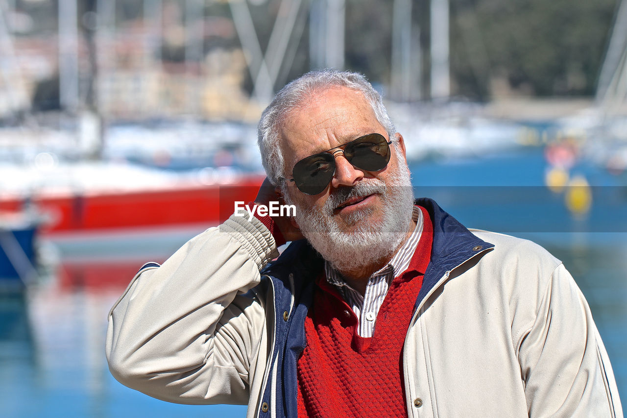 Portrait of man wearing sunglasses by sea