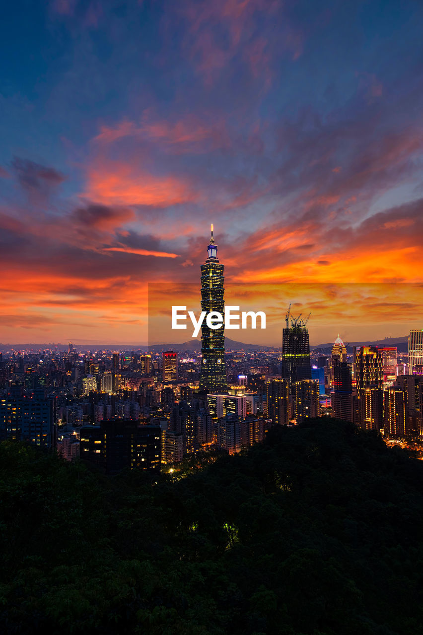 ILLUMINATED BUILDINGS AGAINST CLOUDY SKY DURING SUNSET