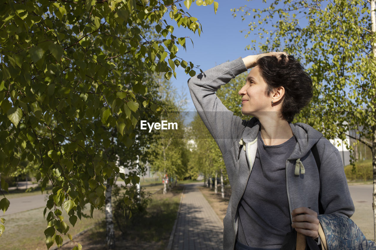 Portrait woman holds trekking sticks, happy caucasian 36 yo hiking female, nordic walking with poles