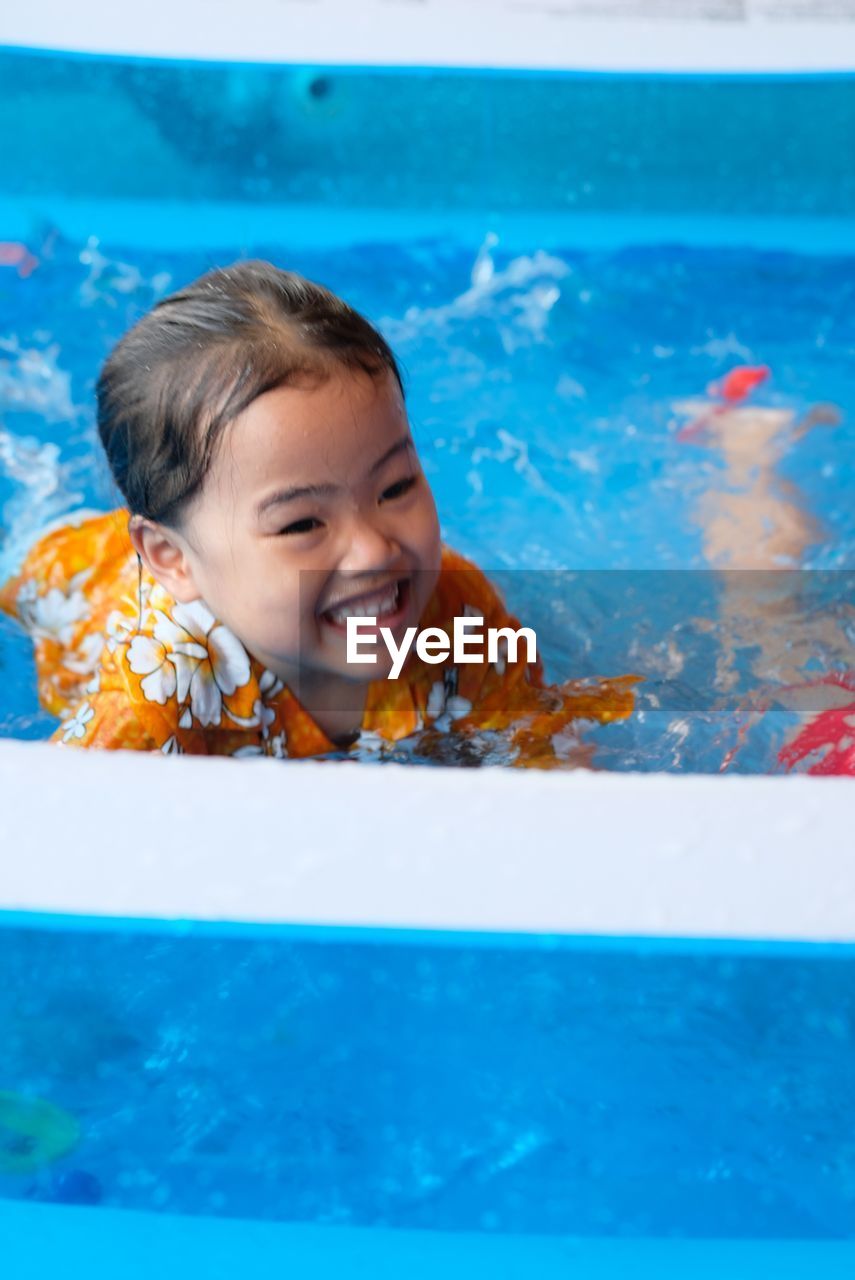Smiling girl swimming in wading pool