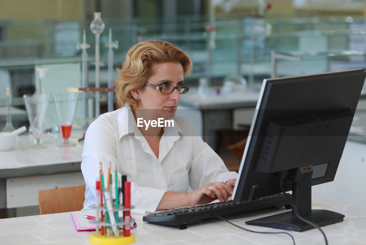 Scientist using computer on desk in office