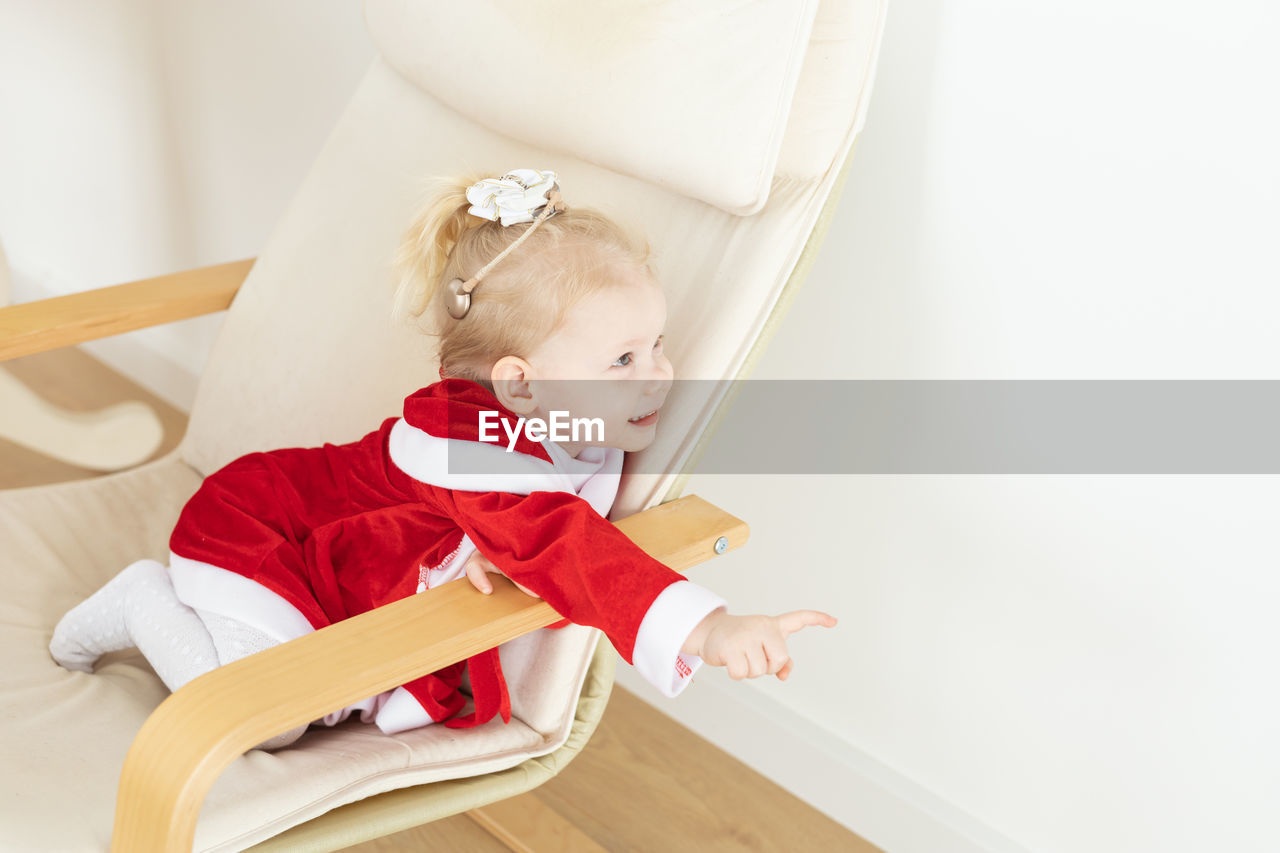 high angle view of cute baby girl sitting on floor at home