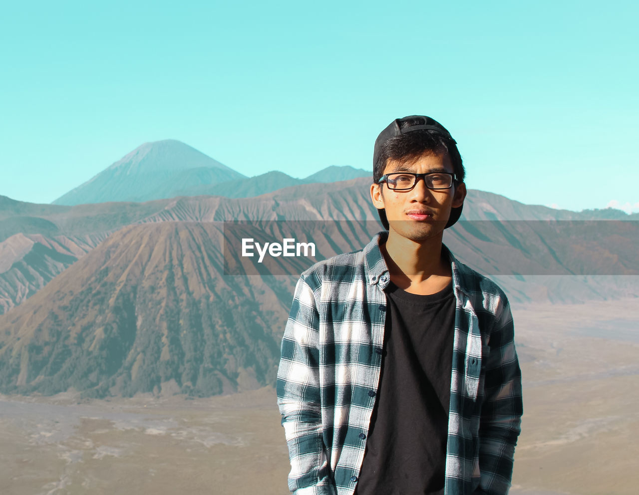 Portrait of young man standing against mountains