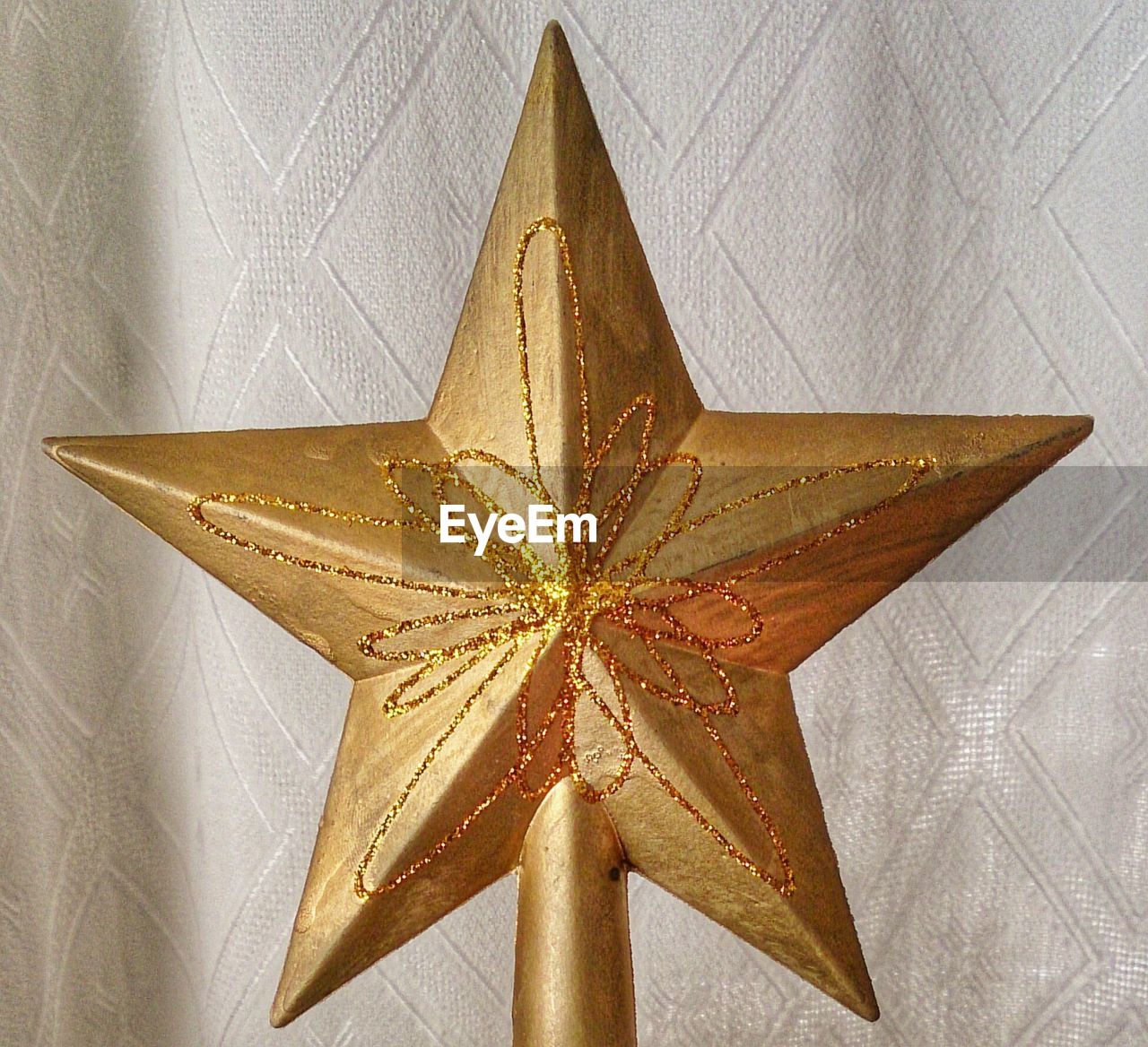 Close-up of star shaped decoration against curtain