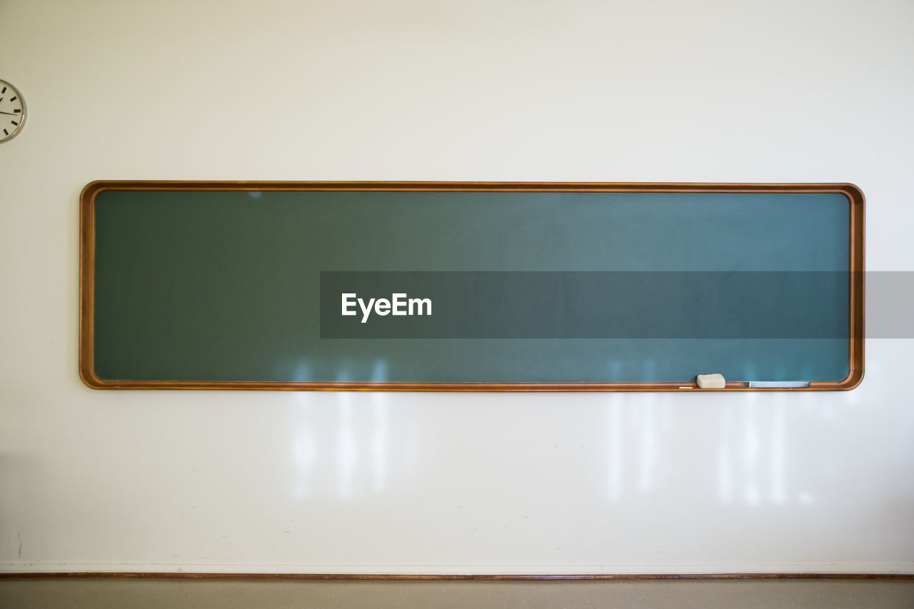 Vintage chalkboard in wooden frame on white wall