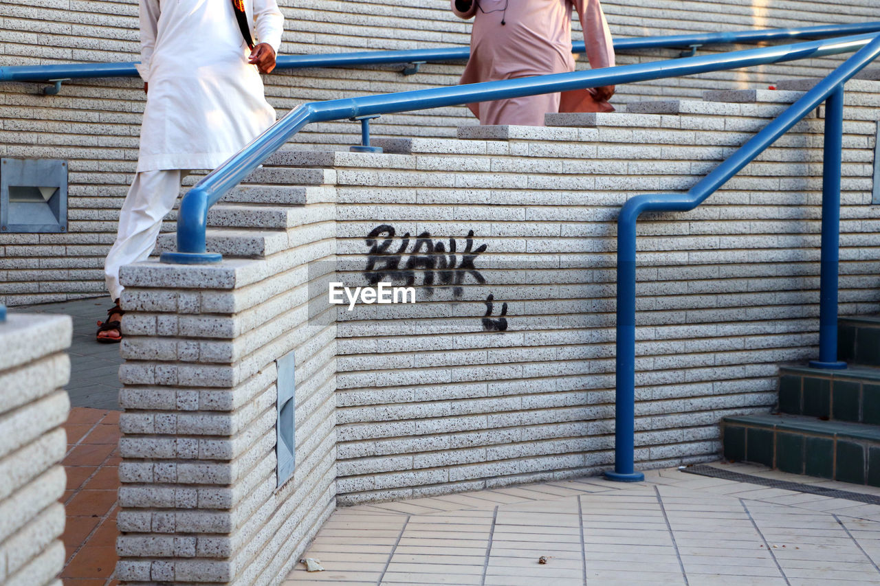 LOW SECTION OF PEOPLE WALKING ON STAIRCASE