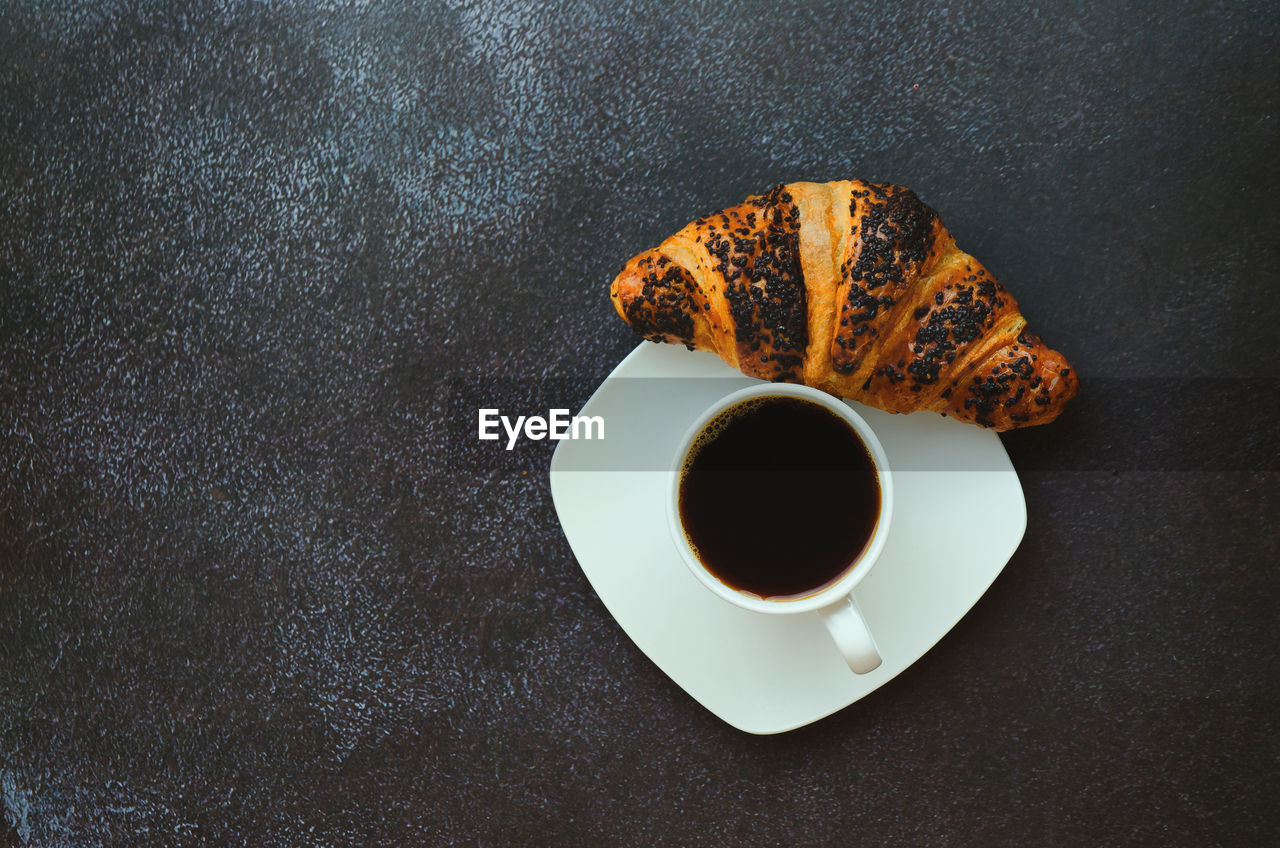 HIGH ANGLE VIEW OF COFFEE CUP WITH SPOON AND SAUCER ON TABLE