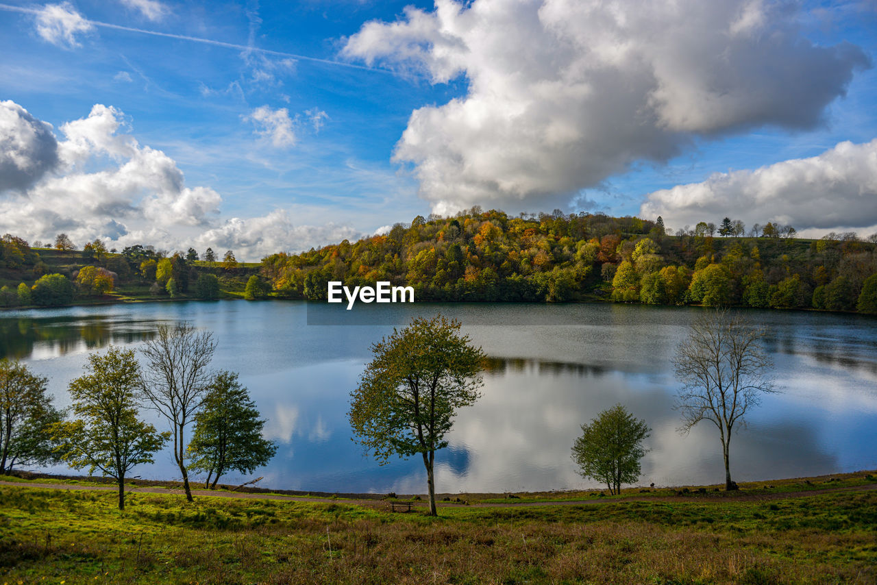 Scenic view of lake by trees against sky