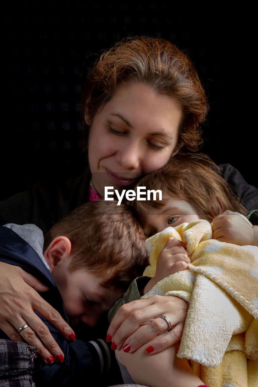 Mother with children against black background