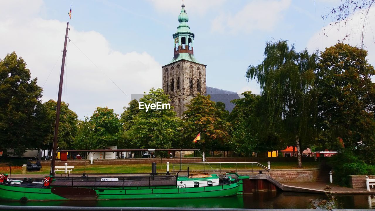 Boats moored at temple against sky