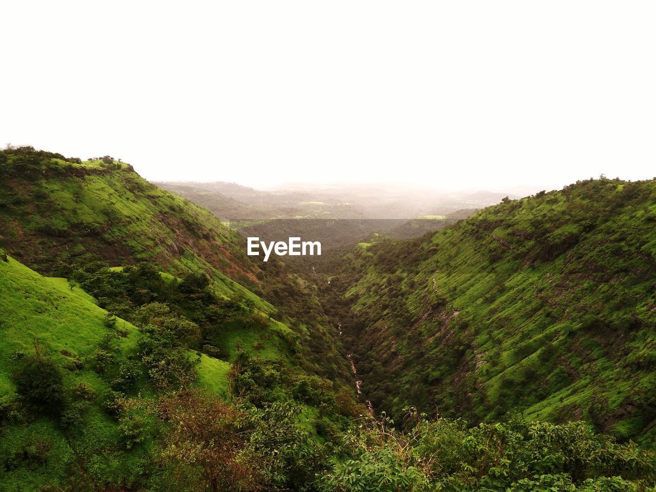 Scenic view of green mountains against sky during monsoon