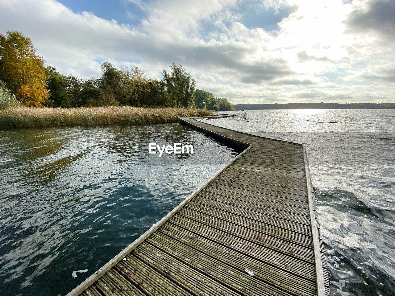 WOODEN JETTY ON LAKE AGAINST SKY