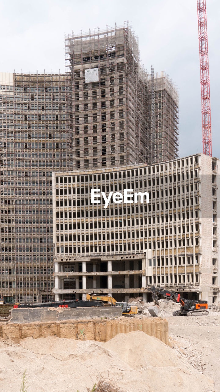 VIEW OF CONSTRUCTION SITE AGAINST BUILDINGS