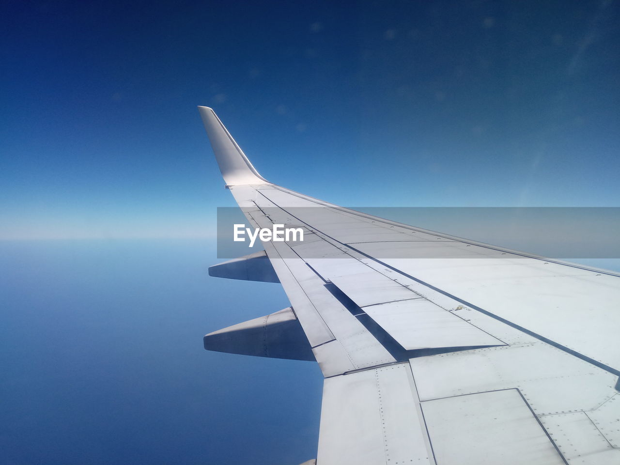 Airplane wings flying in blue sky