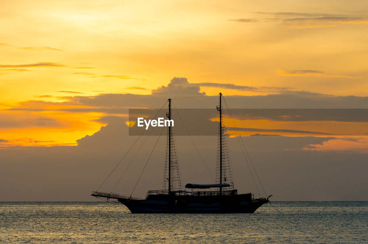 Silhouette sailboat on sea against sky during sunset