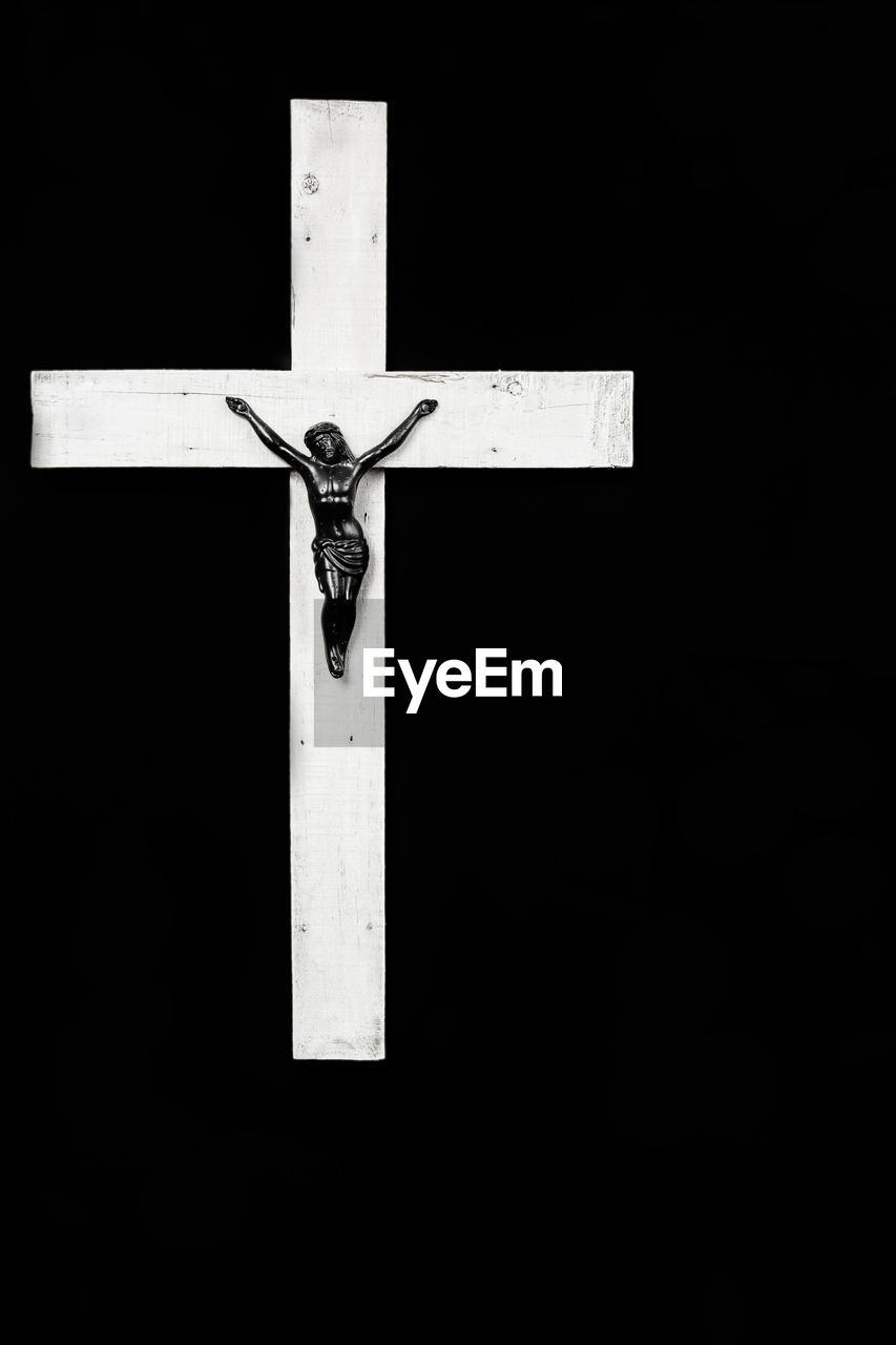 Low angle view of cross against black background