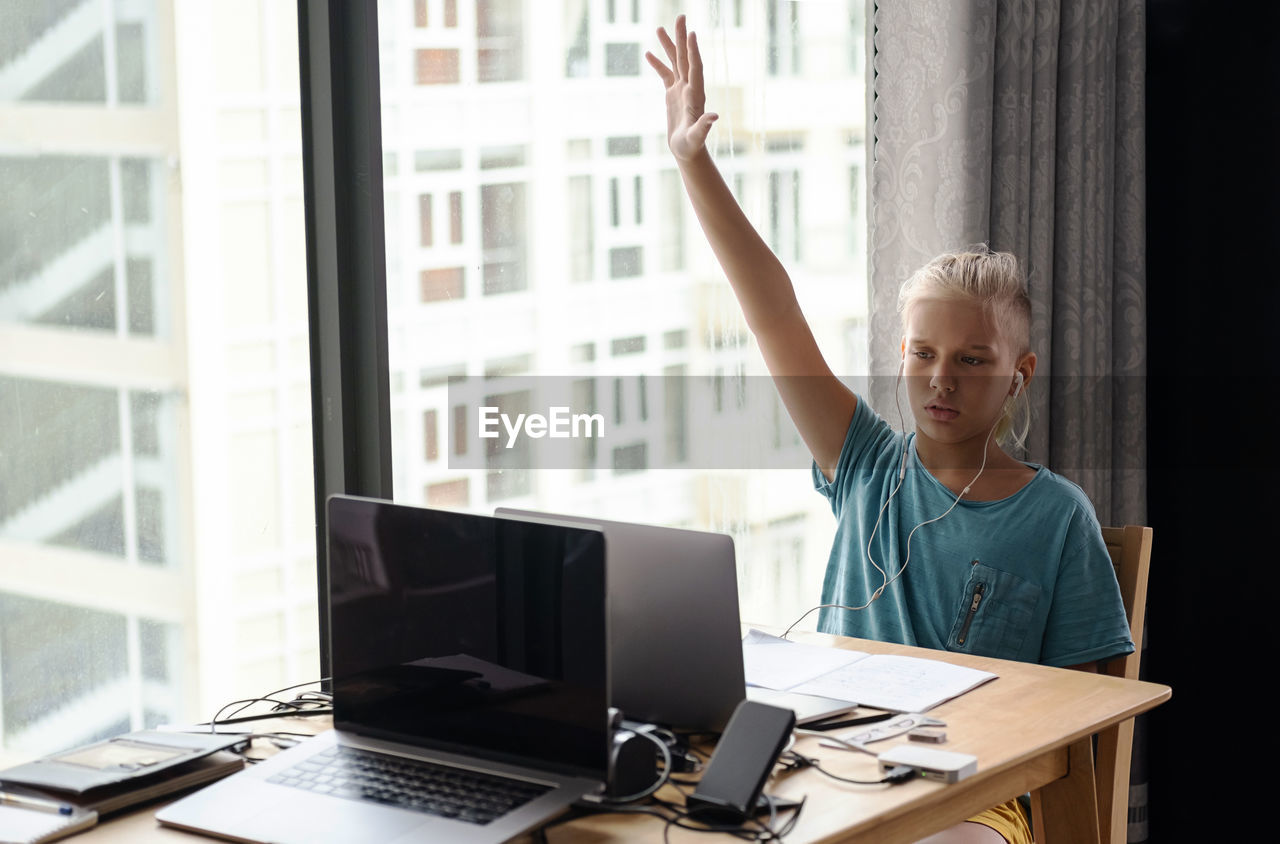 Teenage school boy student wear headphone watch video conference online on laptop. online education 