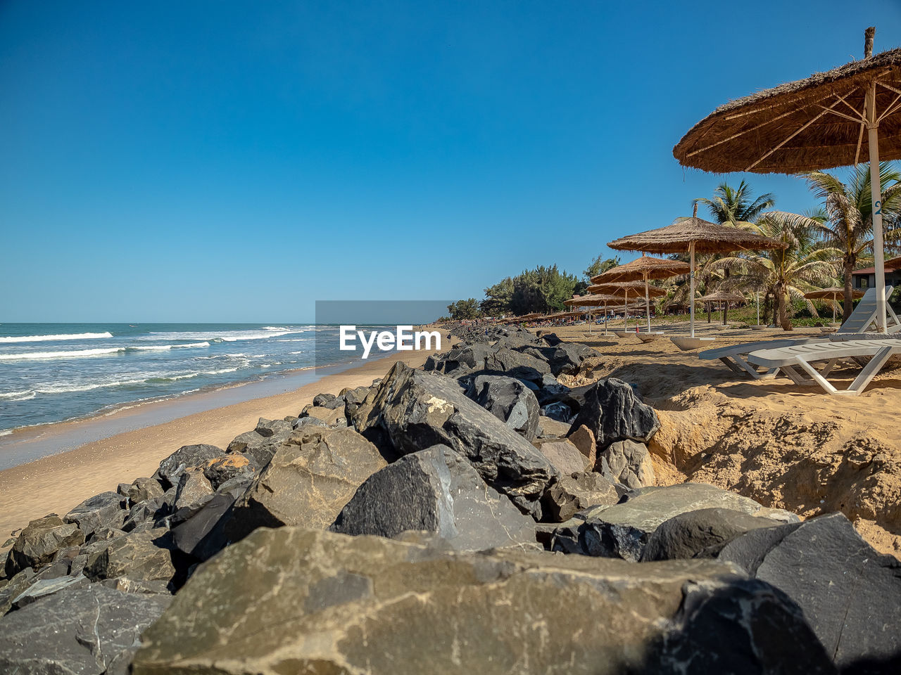 Rocks on beach against clear blue sky