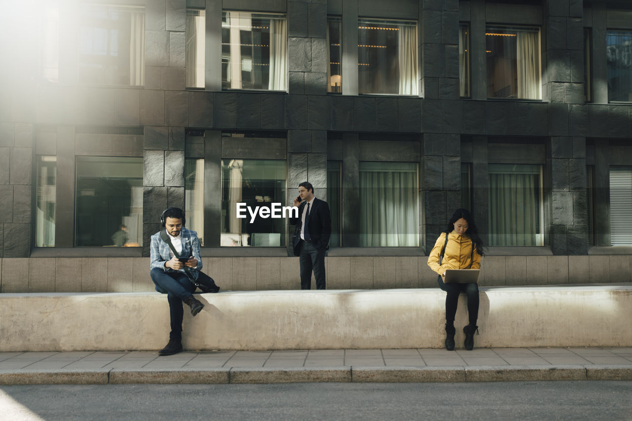 Three people keeping social distancing working outdoors