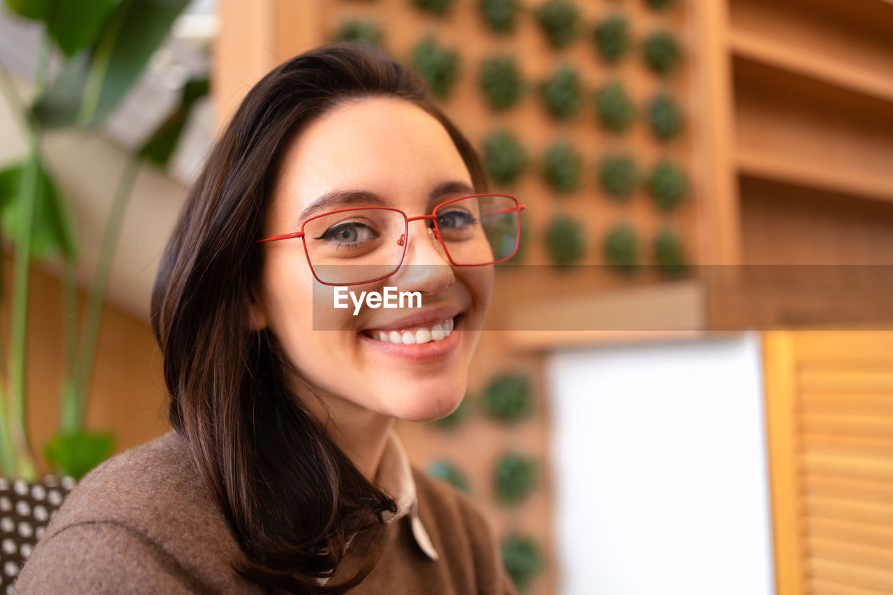 portrait of young woman wearing sunglasses while sitting at home