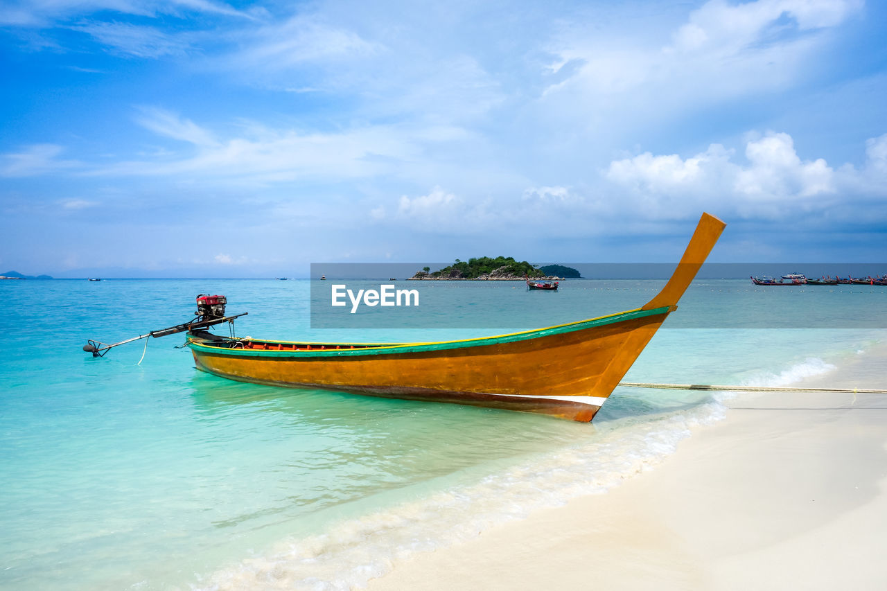 BOAT MOORED ON SEA AGAINST SKY