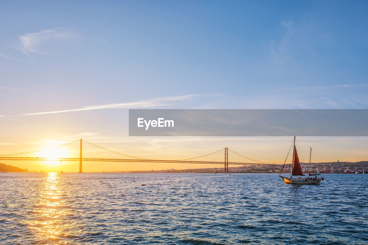 view of suspension bridge over river against sky during sunset