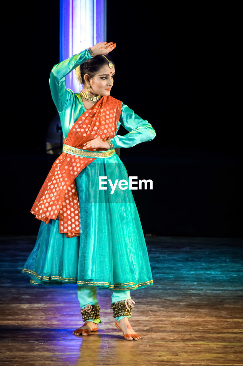 FULL LENGTH OF WOMAN STANDING IN TRADITIONAL CLOTHING