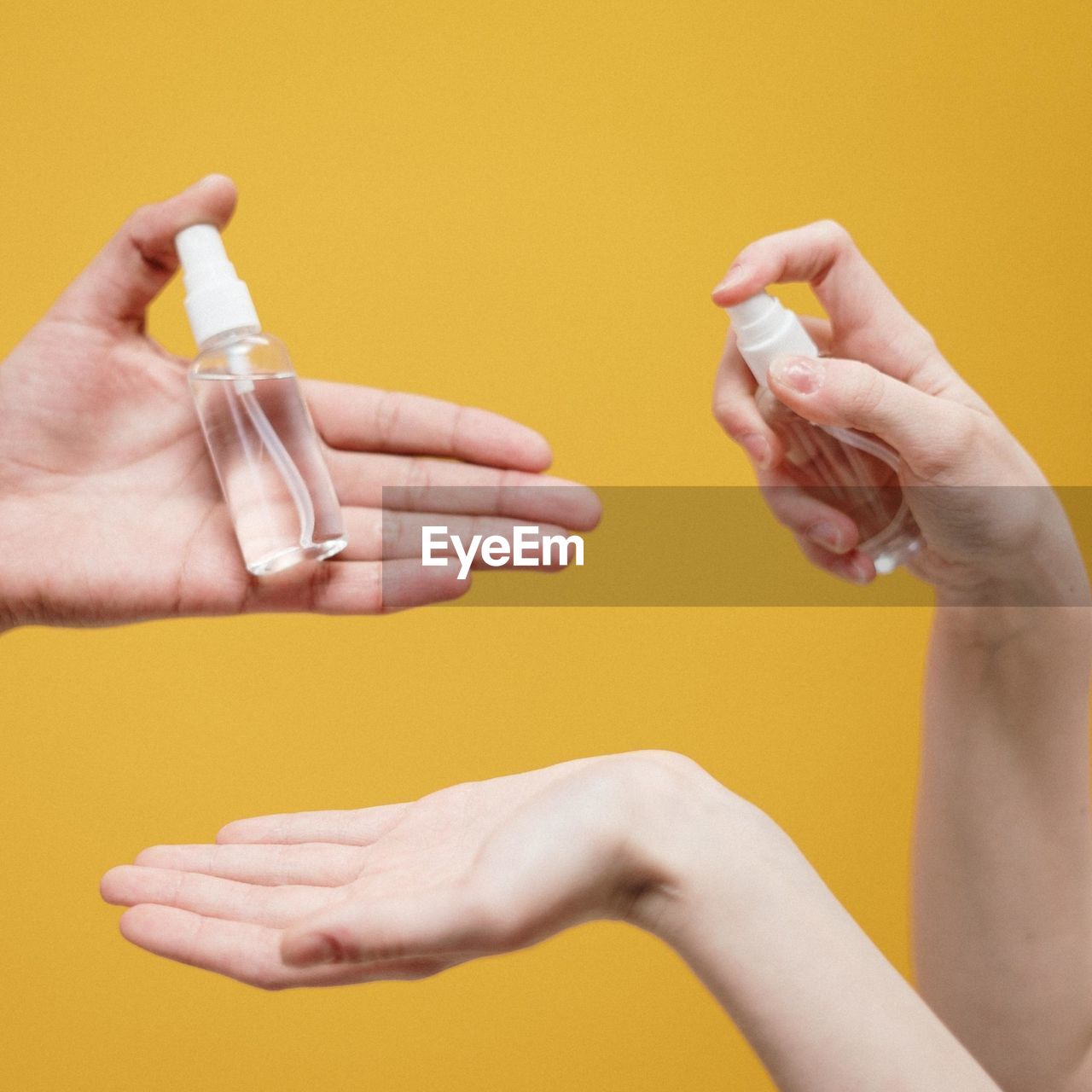 cropped hands of woman holding condom against blue background