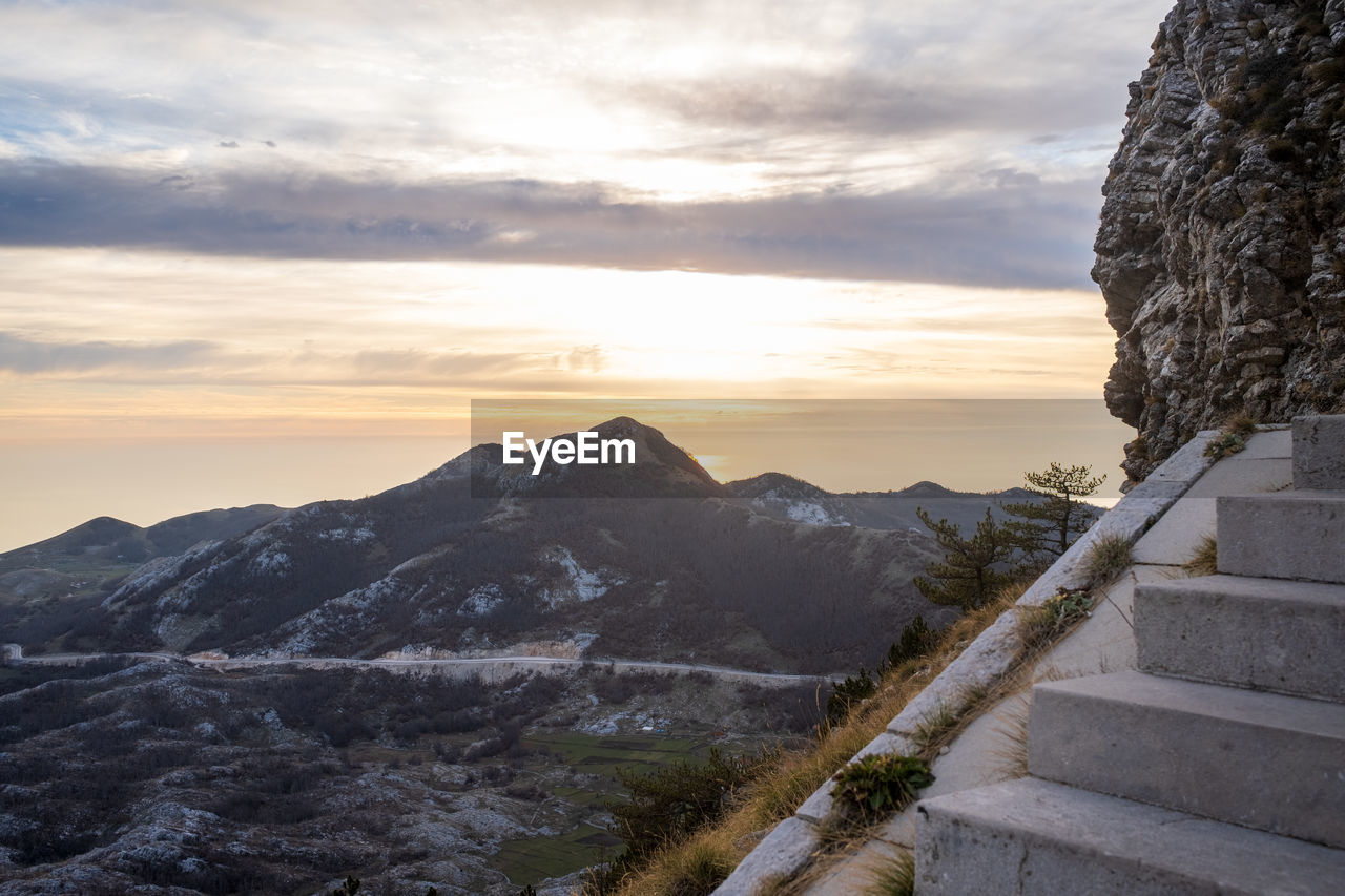 sky, mountain, cloud, scenics - nature, environment, beauty in nature, nature, landscape, sunset, rock, snow, travel, mountain range, architecture, travel destinations, staircase, tranquility, outdoors, no people, tranquil scene, sunlight, tourism, cold temperature, winter, land, dramatic sky, footpath, sun, built structure, plant, tree, non-urban scene, climbing, idyllic, mountain peak, leisure activity