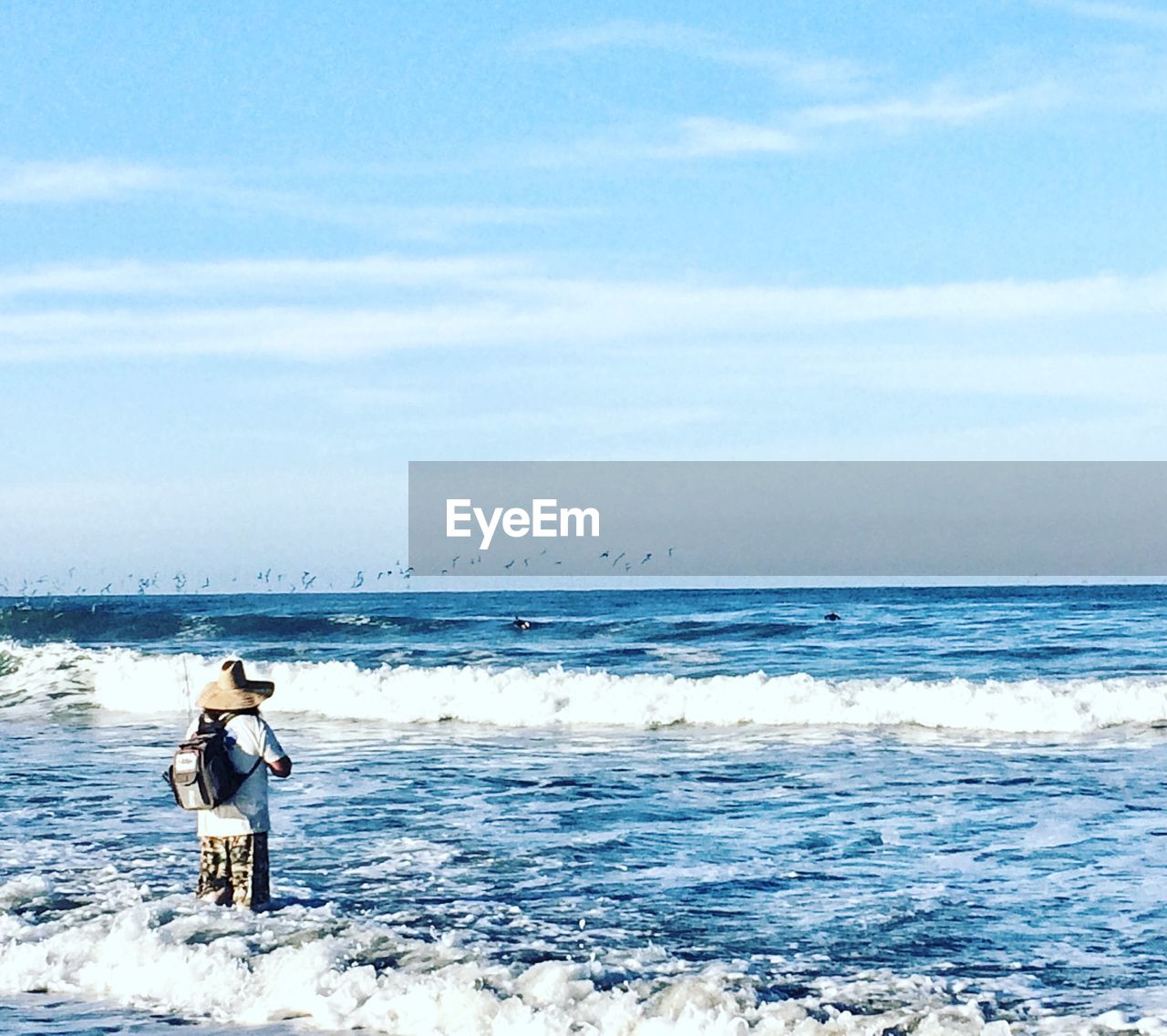 MAN IN SEA AGAINST SKY