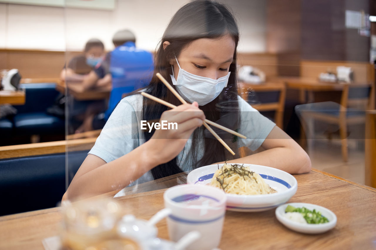 Girl eating food in restaurant