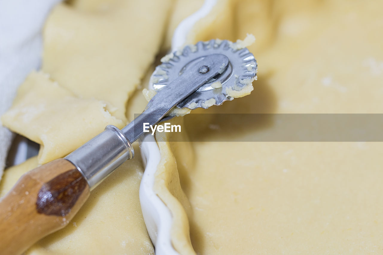 High angle view of pastry cutter on tart dough