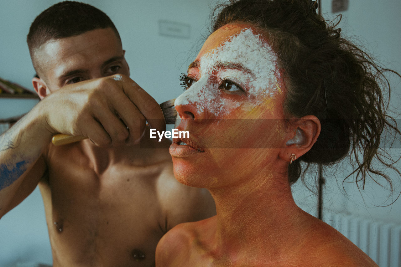 Man applying mask to woman