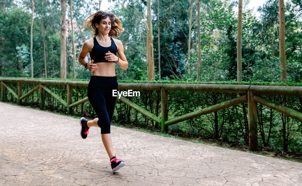 Athlete woman running through a park