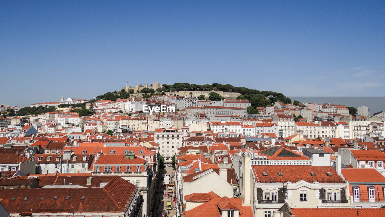 Buildings in town against clear sky