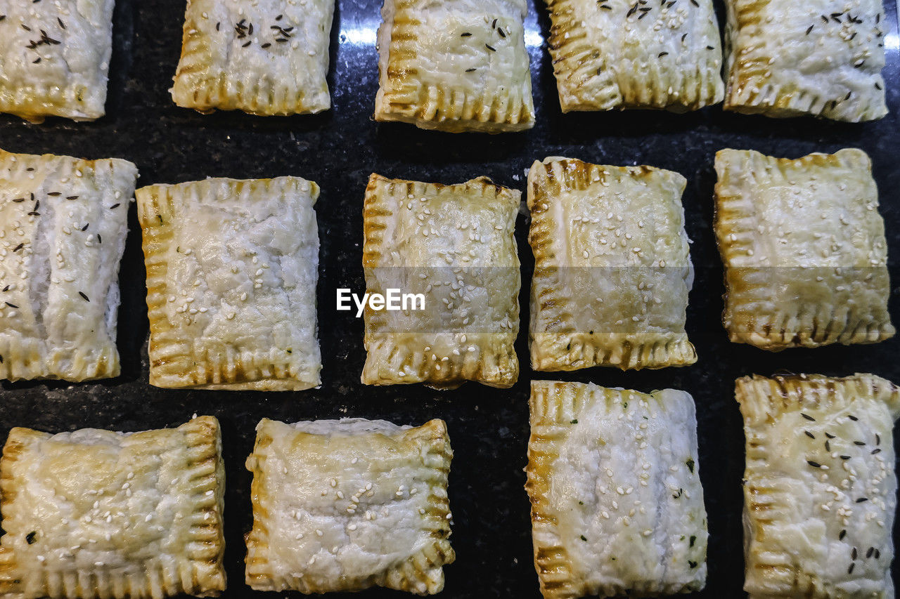 Full frame of freshly baked savoury puff pastry pockets straight out of the oven