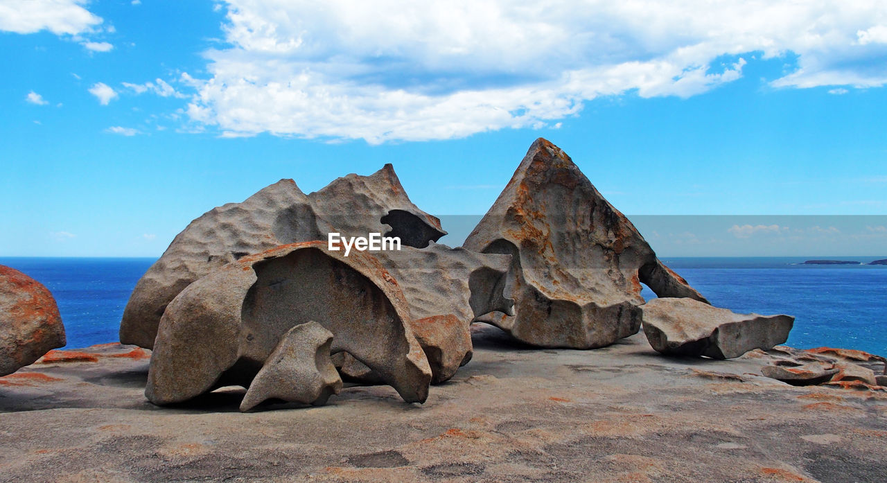 Rock formations on beach against sky