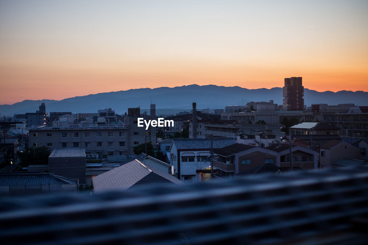 Buildings in city against sky during sunset